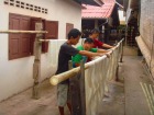 ヴィエンチャンの織物の村でシルク糸を干す男たち