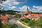山の緑にオレンジの屋根が映えるチェコの街