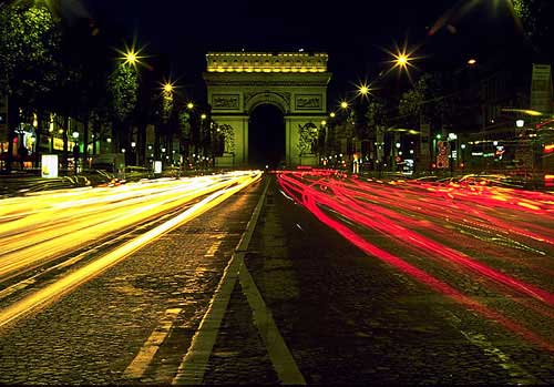 夜のシャンゼリゼ通りにそびえる凱旋門
